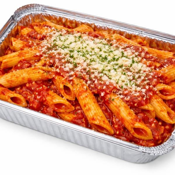 Penne pasta with red sauce, parmesan cheese, and parsley in a foil takeout container.