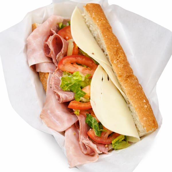 A Rocco's NY Pizzeria & Pasta Italian sub sandwich with ham, salami, cheese, lettuce, and tomatoes.