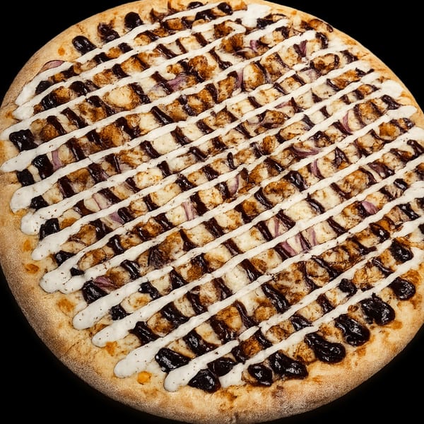 Rocco's NY Pizzeria & Pasta's BBQ chicken pizza with red onions, drizzled with white and dark sauces.
